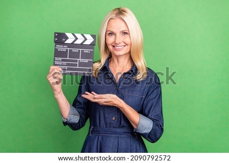 Photo of retired pretty lady advertise present clap board television shooting isolated over green color background