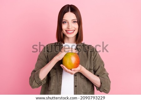 Photo of sweet brunette hairdo millennial lady hold mango wear green shirt isolated on pink color background