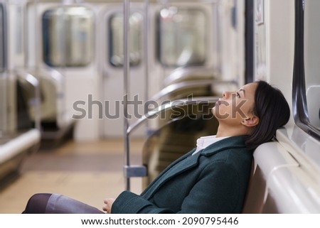 Exhausted american business woman relaxing resting on seat in subway train, returning home after hard working day, sad female office worker in metro underground feels tired after workday Royalty-Free Stock Photo #2090795446