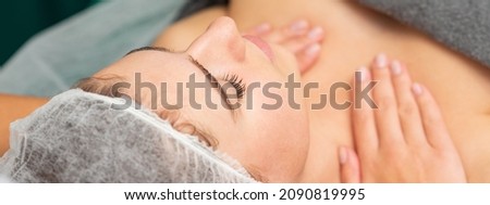 Massaging female chest. Young beautiful caucasian woman with closed eyes getting chest massage at beauty spa salon