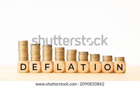 Deflation concept. Text on wooden blocks and stacked coins. Copy space Royalty-Free Stock Photo #2090820862