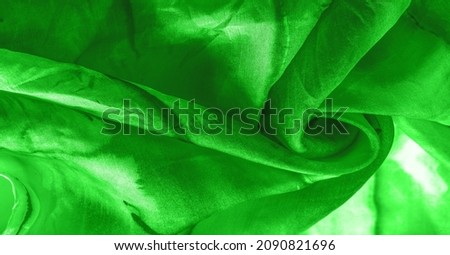 Green fabric with streaks of gray spots on a green background. Abstract designer fabric fancy designer. Beautiful background for your design. Texture. Picture. drawing, pattern, figure