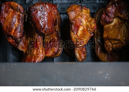 Close up of smoked meat and belly or beech meat with dark crust in the smokehouse or smoker, food concept Royalty-Free Stock Photo #2090829766