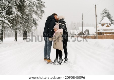 Happy family have fun in winter forest. Mother, father and dauther playing with snow.Enjoying spending time together. Family concept