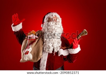 santa claus with bag and ring bell portrait against red background