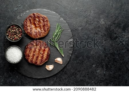 grilled cutlets for making burger on stone background with copy space for your text