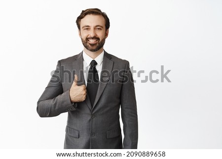 Business people. Handsome realtor, businessman showing thumb up and smiling, wearing suit, standing over white background Royalty-Free Stock Photo #2090889658