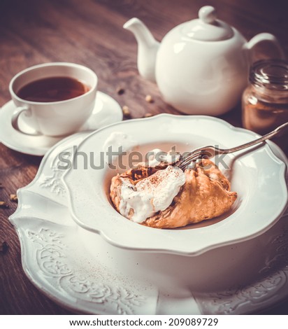 Delicious homemade apple strudel with ice cream on wooden background. Toned picture