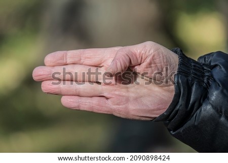 Palm and fingers of an old man showing direction