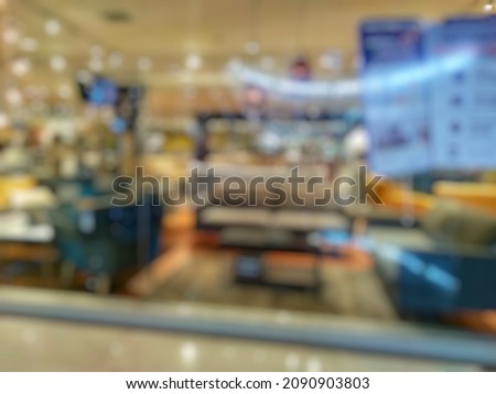 bokeh image of display furniture (sofa and chair sales area) for sale in departement store. Abstract blurred image of Home interior living room concept front view from window in departement store. 
