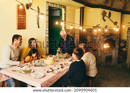 Happy latin family cooking together during dinner time at home - Soft focus on grandfather face Royalty-Free Stock Photo #2090904601