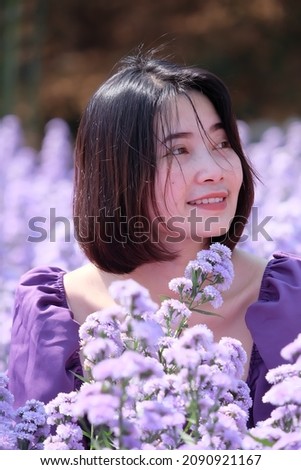 Asian woman smiling happily in the field of margaret flowers purple flowers Colors of the season.