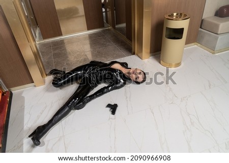 Hit woman. Woman in a latex suit killed in gunfire shot in the chest

 Royalty-Free Stock Photo #2090966908