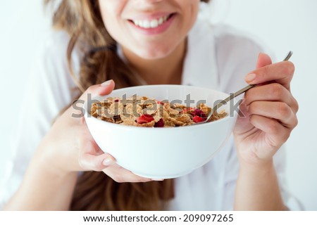 Portrait of young woman in underwear eating cereals. Isolated on white. Royalty-Free Stock Photo #209097265