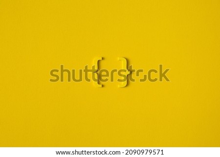 Yellow wooden symbol "bracket" on yellow background and copy space for social media educational concept Royalty-Free Stock Photo #2090979571