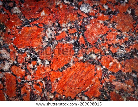 Texture of granite with a bright red, black and white interspersed with vignetting effect