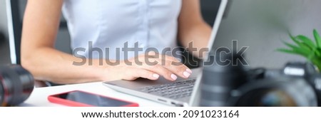 Woman works on computer next to camera. Internet news feed compilation concept