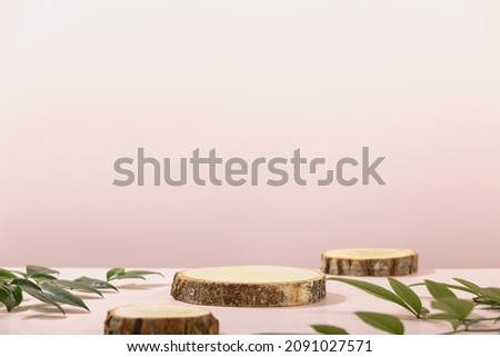 Minimal modern product display on pink background. Wood slice podiums and green leaves. Concept scene stage showcase for new product, promotion sale, banner, presentation, cosmetic Royalty-Free Stock Photo #2091027571