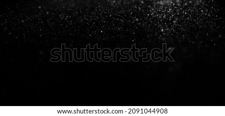 silver glittering star magic dust on black background. Particles on dark backdrop.  glitter star dust blowing. white and  black  Royalty-Free Stock Photo #2091044908