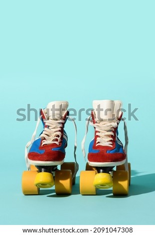 Isolated pair of old fashioned roller skates placed on light blue background in studio