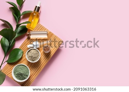 Tray with henna powder and essential oil on color background