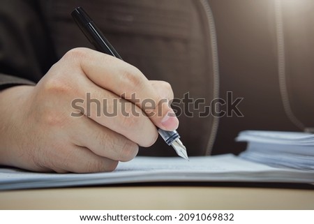 Close up of businessman hand signing document with pen. Business concepts on investment contracts, agreements, and approvals, MOU.