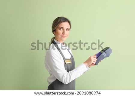 Waiter with payment terminal on color background