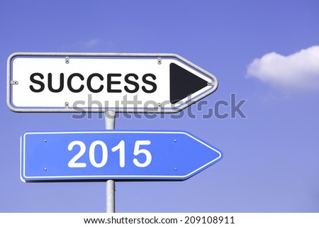 blue sky behind two white and blue road signs  on a metal mast with arrows to the right hand side showing the way to success 2015