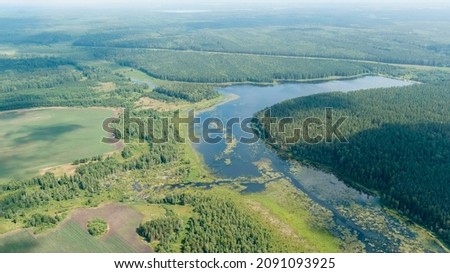 Russia, Ural. Takeoff over fields and forests. Swampy Pond. Clouds with gaps, Aerial View  