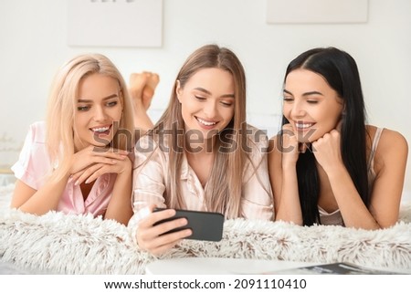 Beautiful young women taking selfie at slumber party
