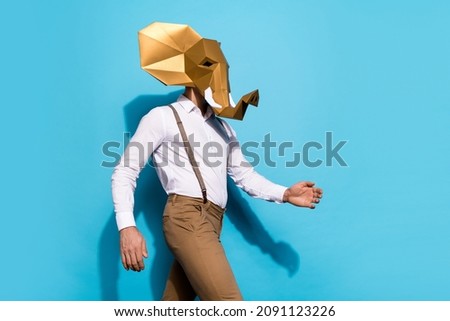 Photo of anonymous freak man wear elephant walking empty space isolated blue color background