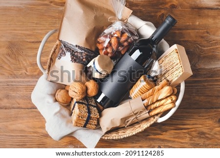Gift basket with products on wooden background Royalty-Free Stock Photo #2091124285