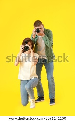 Young photographers on color background