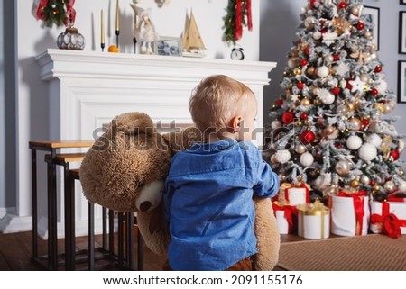 Little baby boy with huge teddy bear.