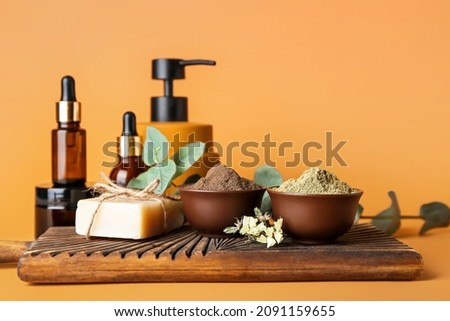Composition with henna powder and cosmetics on color background