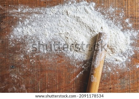 flour and rolling pin on wooden table