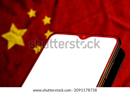 Mockup image of a smartphone with the blank white screen and Chinese flag on the background. 