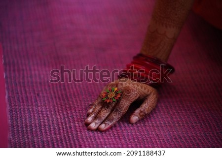 The bride's hand in the wedding dress with wearing bangles and henna-painted.