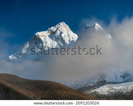 View to hide snow peaks after clouds in mountain valley in Nepal