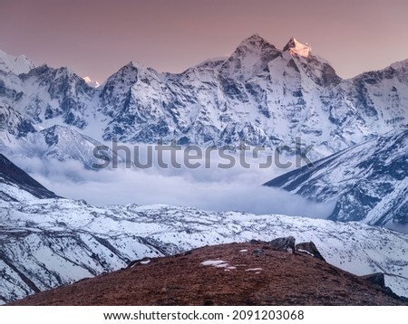 view to mountain valley after sunrise with clouds between valley and snow peaks in Nepal