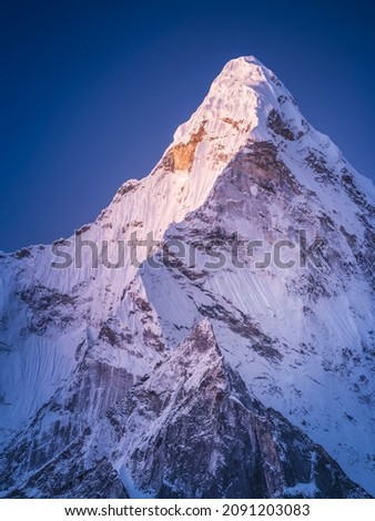 Narrow triangle snow peak in pre-sunrise light in Nepal