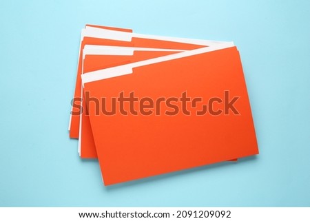 Orange files with documents on light blue background, top view Royalty-Free Stock Photo #2091209092
