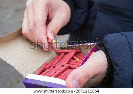 Pyrotechnics for the holiday. Petard or firecrackers in the hands of a boy. Royalty-Free Stock Photo #2091211864