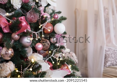 Christmas, xmas, New Year interior with gold and brown fur-tree, fir tree decoration with balls and flowers, grey cover and lantern  