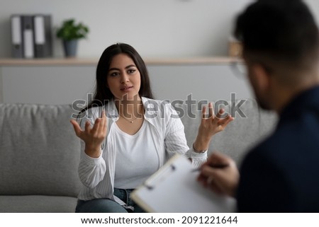 Professional psychological help concept. Depressed arab woman talking to psychotherapist at office, female patient having consultation with counsellor