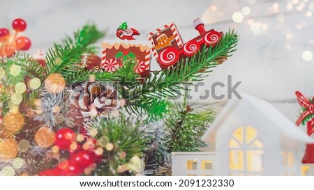 Christmas train on a spruce branch on a light background with snow and copy space