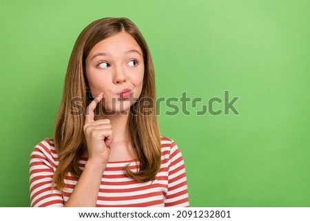Photo of youth pretty lady finger touch chin look empty space think wonder isolated over green color background