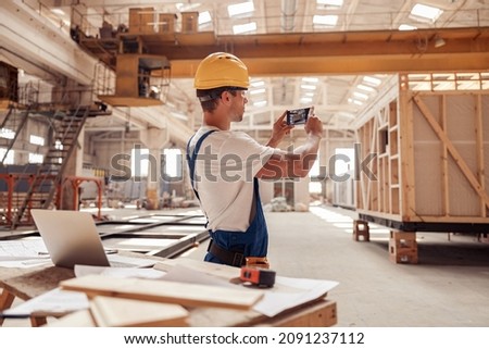Male builder taking picture at construction site