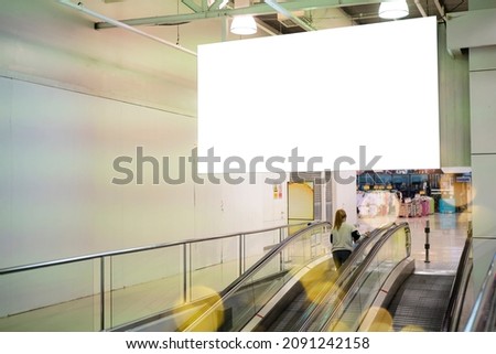 Blank large horizontal poster in public places. A mockup billboard near escalator in airport building, office building or subway station. 3D display.