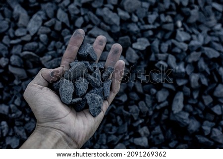 Coal mining : coal miner in the man hands of coal background. Picture idea about coal mining or energy source. Industrial coals. Volcanic rock.